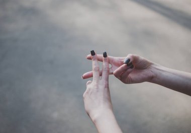 Kız bir hashtag yapma jest karşı gri asfalt güneş ışığı ile kaplı. Yakın çekim. Internet, sosyal medya ve online iletişim kavramı