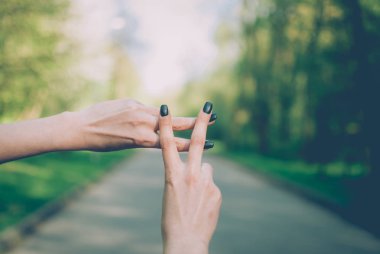 Kız bir hashtag yapma jest güneşli yeşil doğal bir arka plana dayanır. Yakın çekim.