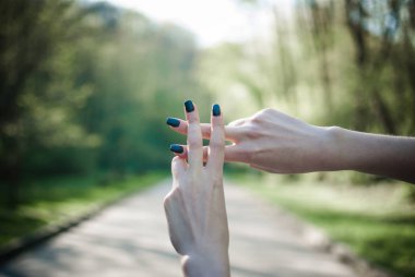 Kız bir hashtag yapma jest güneşli yeşil doğal bir arka plana dayanır. Yakın çekim.