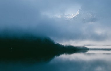 Avusturya Alplerinde görünümü hoş manzara. Sabah erken Nehri mavi günbatımı sis ile kaplı. Bulutların üzerinde görülen dağ.