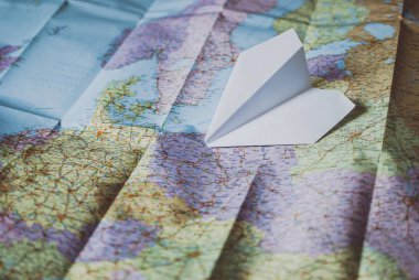 Traveler's yol haritası üzerinde döşeme beyaz kağıt uçak. Retro Vintage renk.
