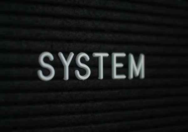 文字系统写在信板上 黑色背景上的白色字母 — 图库照片