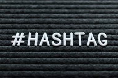 Hashtag kelime # hashtag mektup tahtada yazılı. Siyah zemin üzerine beyaz harfler.