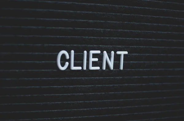 Word client written on the letter board. White letters on the black background. Business concept