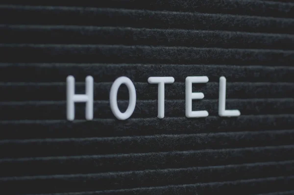 文字旅馆写在信板上 黑色背景上的白色字母 经营理念 — 图库照片