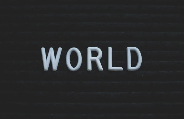 Word world written on the letter board. White letters on the black background. Business concept