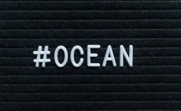 Hashtag word #ocean written on the letter board. White letters on the black background.