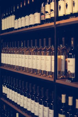 Mtsheta, Gürcistan - 11 Temmuz 2018: Şişe şarap yaz güneş ışığı tarafından örtülü kafe raflarda. Vintage renkleri