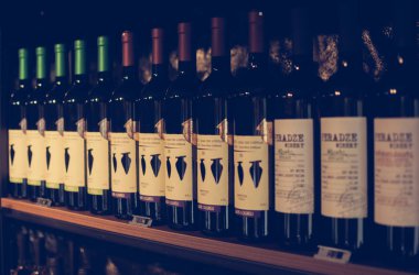 Mtsheta, Gürcistan - 11 Temmuz 2018: Şişe şarap yaz güneş ışığı tarafından örtülü kafe raflarda. Vintage renkleri