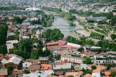Panoramik eski Tiflis, Gürcistan'ın başkenti. Şehrin üzerinde teleferik. Sıcak güneşli öğleden sonra. Kırmızı çatılar eski evler.