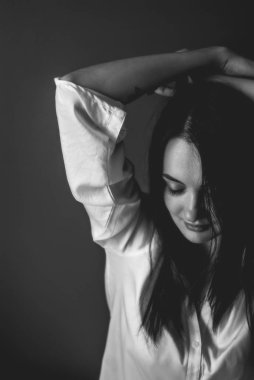 Gözleri ile oldukça solgun esmer kapalı. Mutlu rüya kız atmosferik portresi. Mavi duvar arka planda. Acı-tatlı bir atmosfer. Siyah ve beyaz