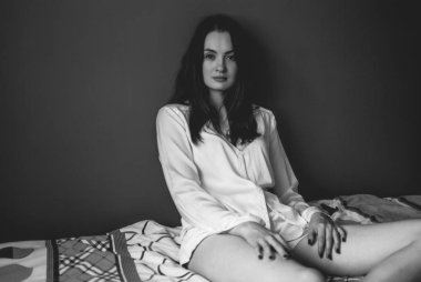 Siyah beyaz portre yakışıklı bir beyaz esmer kameraya bakıyor. Derin gölgeler ve yüksek karşıtlık. Pretty genç kız evde tek başına