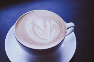 Cappuccino bir soyut bir kahverengi kahve köpük üzerinde çizim ile beyaz fincan. Zarif kahve sanat. Kavram arka plan kafe, dinlenme, eğlence ve romantik ayarlar. Yukarıdan görüntülemek.