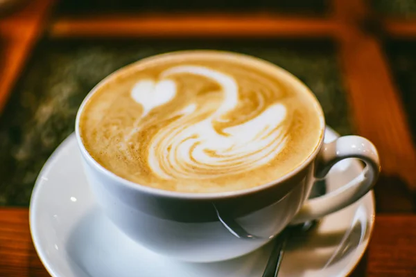 白色的一杯咖啡 上面画着一只用棕色咖啡泡沫画的白色天鹅 优雅的咖啡艺术 咖啡馆 休闲和浪漫环境的概念背景 — 图库照片