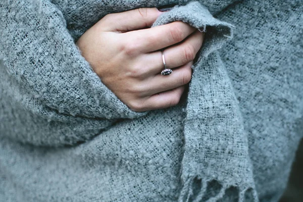 Girl's elegant pale hands covered in warm gray blanket. Silver r — Stock Photo, Image