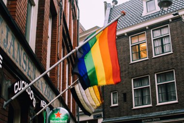 Amsterdam, Hollanda - 6 Şubat 2019: Pencerenin altındaki binaya gökkuşağı bayrağı asılmış. Lgbt ve Lgbtq hareketlerini temsil eden sembol.