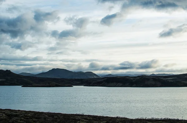 İlkbaharda İzlanda'nın muhteşem manzarası. Gölün mavi suyu ve yeşil sisli dağların rüya gibi manzaralar üzerinde erken beyaz gece parlak alacakaranlık. — Stok fotoğraf
