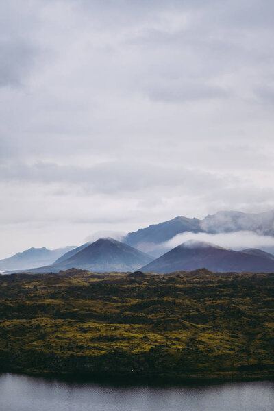 Beautiful green Icelandic landscapes with misty mountains on the horizon