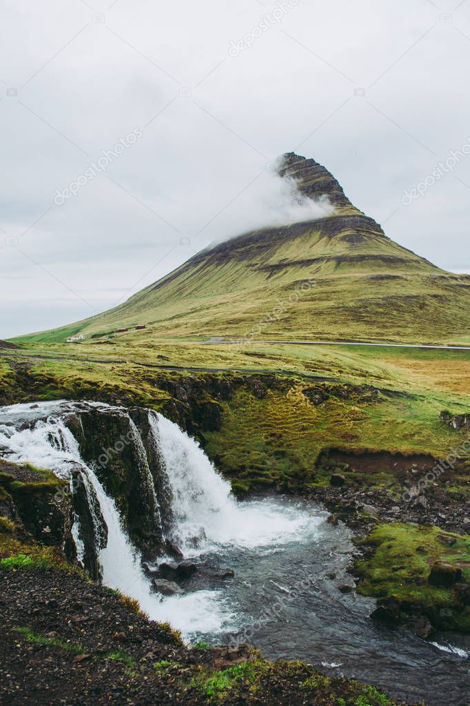 Famous view of Kirkjufellsfoss waterfall and mountain. One of the most memorable sceneries to see and experience in Iceland.