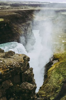 Gullfoss şelalesinin suları kayaların arasında nehre düşüyor. İzlanda Manzaraları