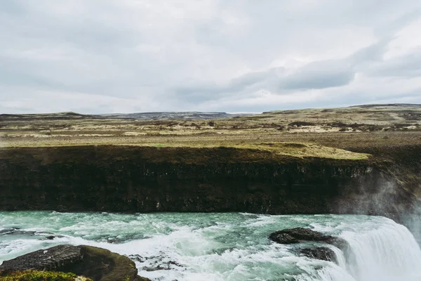Horisontell vy över Gullfoss vattenfall i sydvästra Island. Blått och grönt vatten med blekt vita stänk som flyger över den. Isländska landskap. — Stockfoto