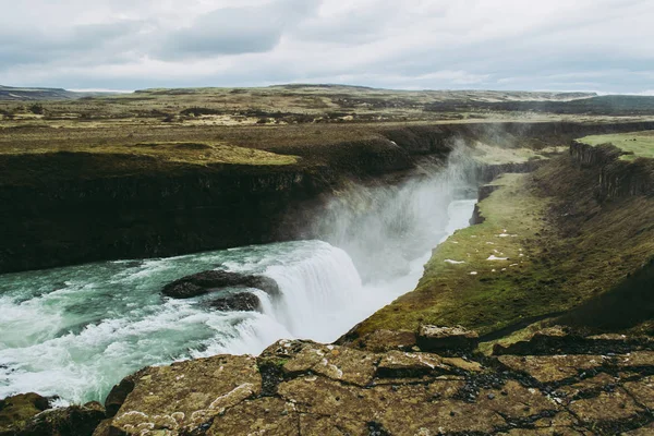 As águas verdes e azuis da cachoeira Gullfoss na Islândia. Nuvens de salpicos voando no ar — Fotografia de Stock