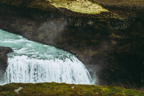 Turquoise water falling into the abyss. Famous Icelandic waterfall of Gullfoss in spring