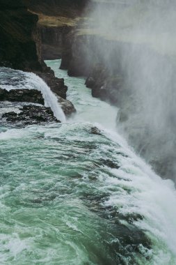 Gullfoss şelalesinin kenarı ve üzerinde uçan su sıçrayışları