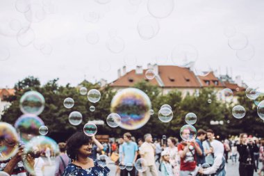 Prag, Çek Cumhuriyeti - 17 Ağustos 2019: Şehrin Ortaçağ mimarisine karşı uçan renkli baloncuklar. Konaklamalarının tadını çıkaran turistler