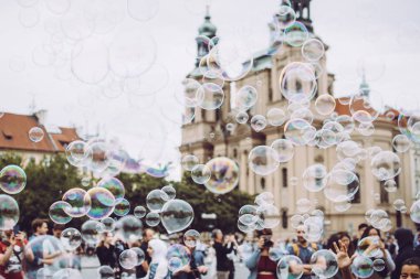 Prag, Çek Cumhuriyeti - 17 Ağustos 2019: Şehrin Ortaçağ mimarisine karşı uçan renkli baloncuklar. Turistler konaklamalarının tadını çıkarıyor