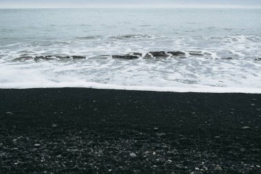 Reynisfjara, İzlanda'daki siyah kum plajı ve Atlantik Okyanusu'nun gri suları