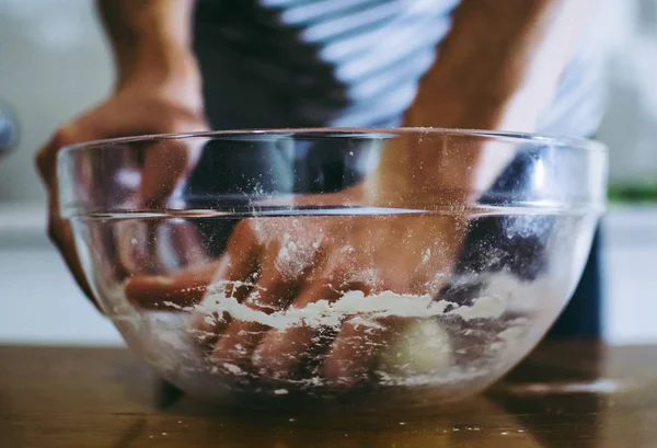 Man kneading pizza dough in the transparent plate Stock Picture