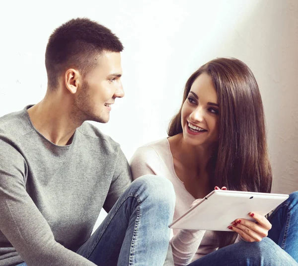 男人和女人用平板电脑和一个盒子 年轻夫妇浏览互联网与 在一个新的家庭概念中移动 — 图库照片