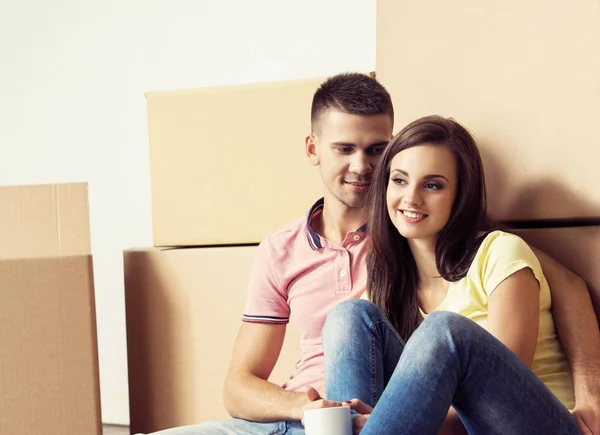 男人和女人搬进新房子 爱的情侣在一个新的家 带盒子的人 图库照片