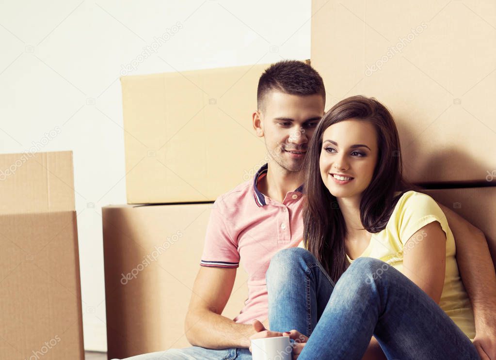 Man and woman moving in a new house. Loving couple in a new home. People with a boxes.