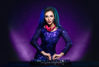 Young, attractive and beautiful and sexy dj girl playing music on a disco party in a night club clipart