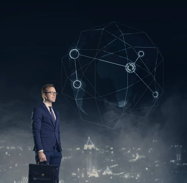 Businessman with briefcase looking on world globe on a night city background.  Job, business, career, concept.