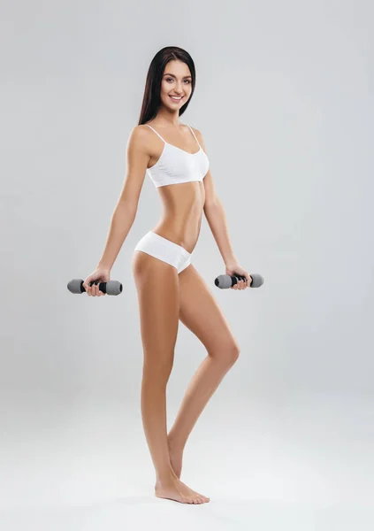 分離したダンベルをくみ上げる若い スポーティなフィットの少女 スポーツ フィットネス 健康的なライフ スタイルのコンセプト — ストック写真