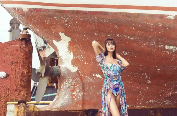 感性和性感的时尚模型在泳装摆在老生锈的船前 — 图库照片