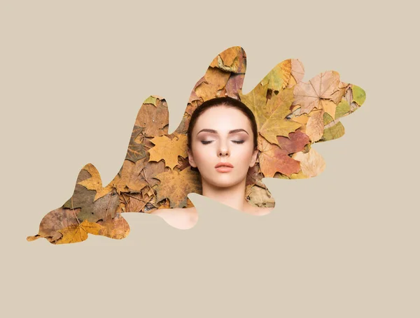 Beautiful face of young, natural and healthy girl over fallen leaves. Healthcare, spa, makeup and face lifting concept with honeycomb grid over autumn background.