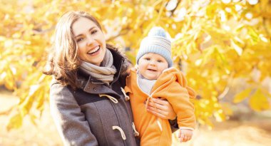 Park toddler bebek ile oynarken annesi. Anne ve oğlu mevsim sonbahar arka plan üzerinde. Aşk ve Aile kavramı.