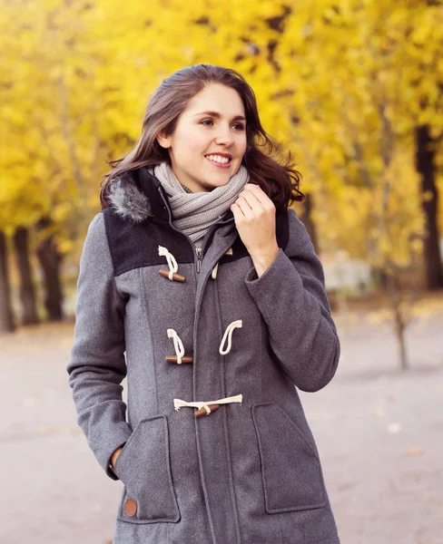 Vacker kvinna promenader i parken. Flicka över säsongens höst bakgrund. — Stockfoto