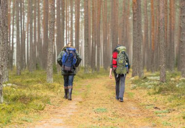 Kamp, macera, seyahat ve dostluk kavramı. Adam bir sırt çantası ve sakal ve arkadaşı ormanda hiking.