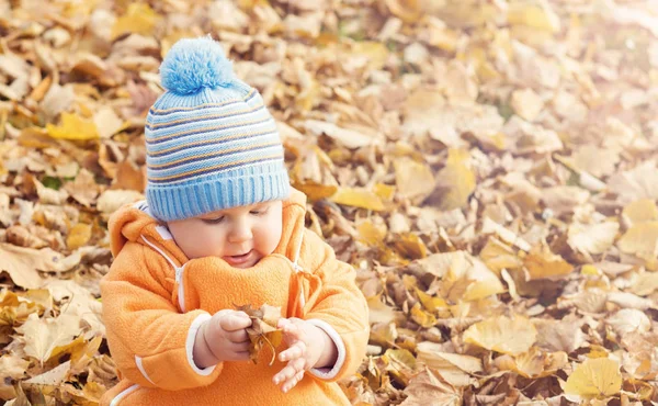 Šťastný chlapec dítě hraje s listy na podzim park. — Stock fotografie