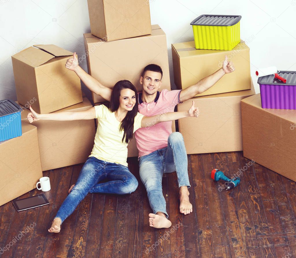 Young loving couple moving in a new house. Man and woman with tools and boxes. Home renovation and reconstruction concept.