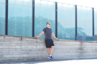 Genç ve spor giyim açık eğitim sportif adam. Yakışıklı ve formda adam sokakta. Spor, sağlık, fitness ve kentsel atletizm.