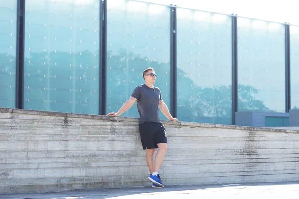 Genç ve spor giyim açık eğitim sportif adam. Yakışıklı ve formda adam sokakta. Spor, sağlık, fitness ve kentsel atletizm.