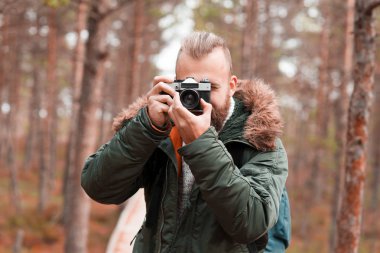Sakallı adam bataklıklarında yürüyüş ve fotoğraf çekmek sırt çantası ile. Kamp, macera, seyahat ve balık tutma kavramı.