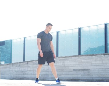 Genç ve spor giyim açık eğitim sportif adam. Yakışıklı ve formda adam sokakta. Spor, sağlık, fitness ve kentsel atletizm.