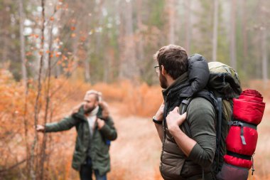 Ormanda hiking sırt çantaları ile iki sakallı adam. Kamp, macera, seyahat ve balık tutma kavramı.  